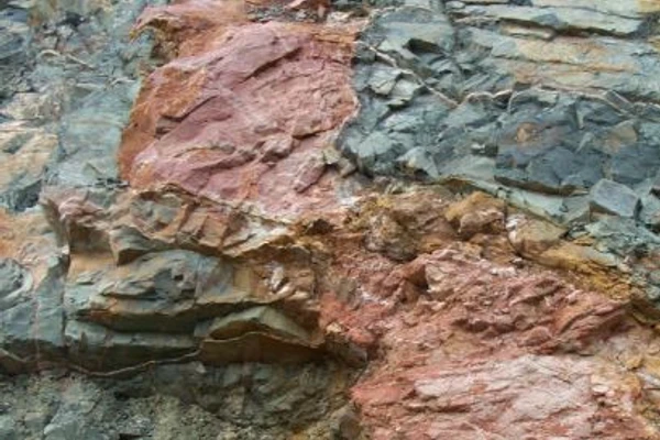 Archean syenites (pink) of the Eastern Goldfields alkaline province intruding metamorphosed basalts (green-grey) at the Jupiter gold deposit in the Yilgarn Craton, Western Australia